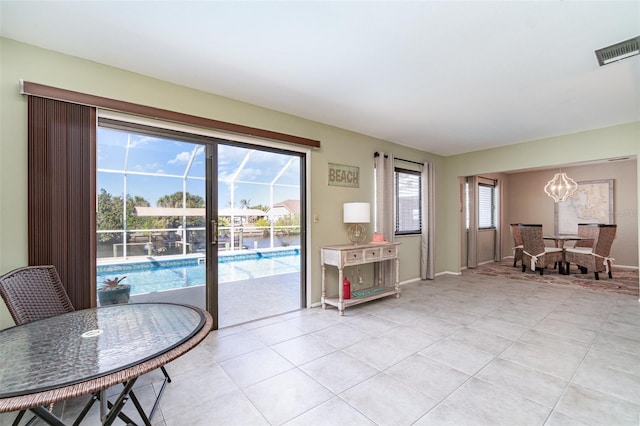 entryway with light tile patterned floors, a chandelier, visible vents, and baseboards