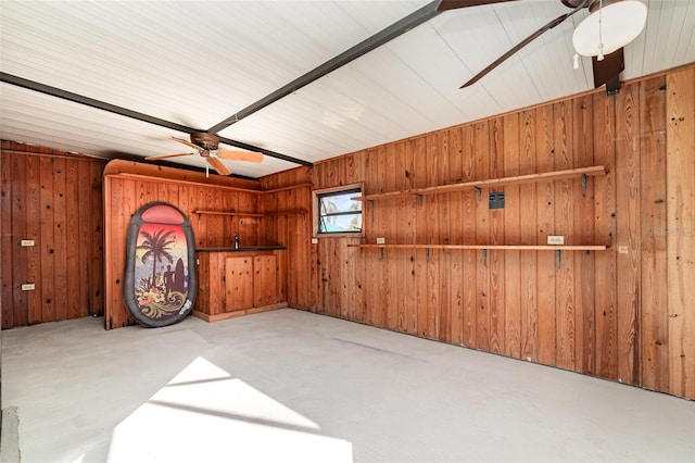 spare room with wood walls and a ceiling fan