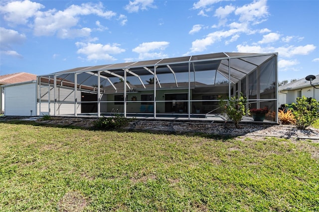 rear view of house with a lanai and a yard