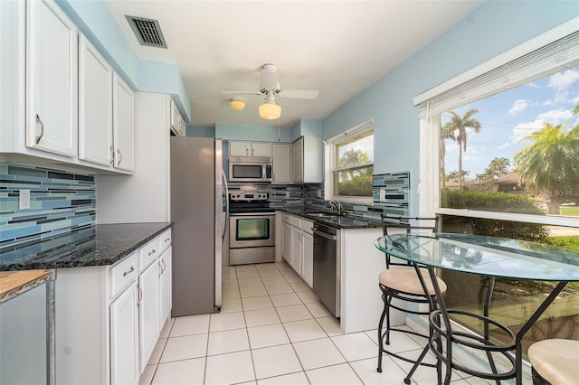 kitchen featuring visible vents, white cabinetry, stainless steel appliances, and a sink