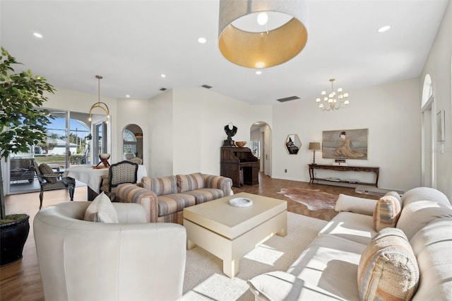 living area featuring arched walkways, a chandelier, visible vents, and recessed lighting