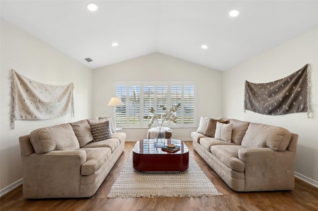 living area with lofted ceiling, visible vents, baseboards, and wood finished floors