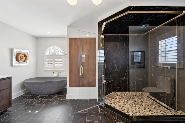 bathroom featuring marble finish floor, baseboards, a tile shower, and vanity