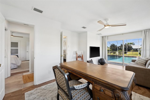 office space featuring ceiling fan, visible vents, and baseboards