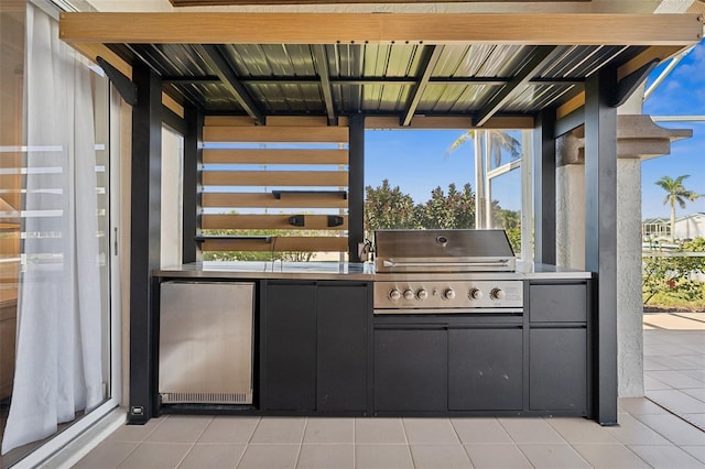 view of patio featuring exterior kitchen and a grill