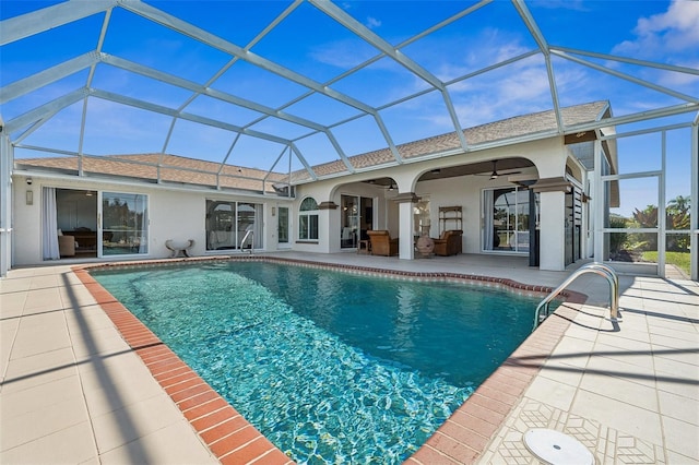 outdoor pool featuring a ceiling fan, a patio area, and glass enclosure