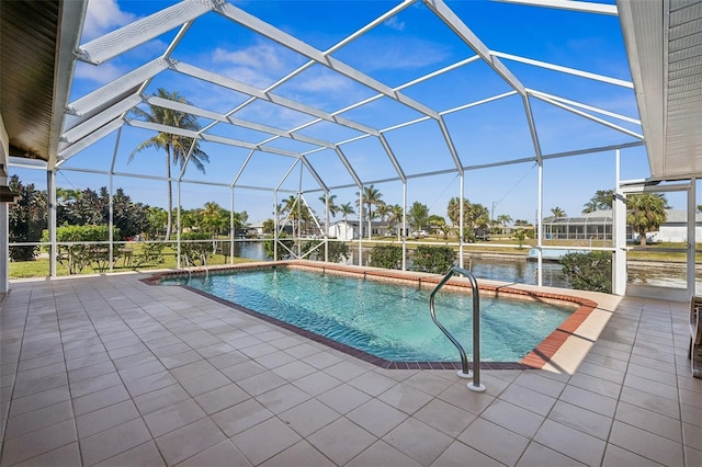 outdoor pool featuring a lanai, a water view, and a patio area