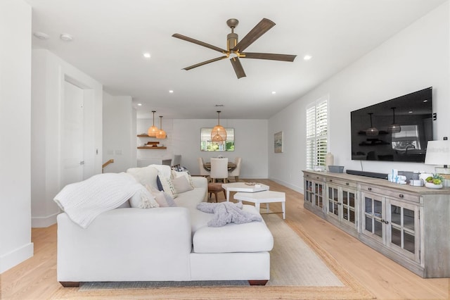 living room featuring baseboards, recessed lighting, and light wood-style floors