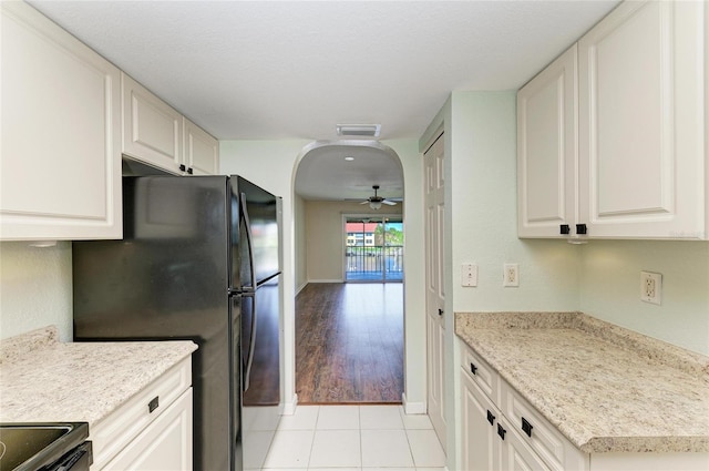 kitchen featuring arched walkways, light countertops, ceiling fan, and visible vents