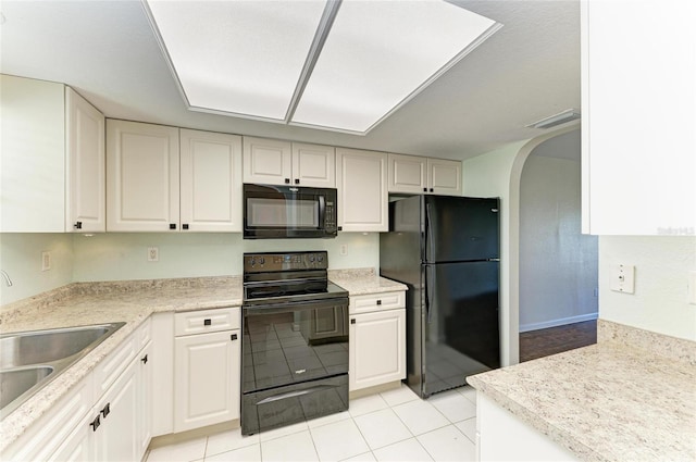 kitchen featuring arched walkways, light countertops, visible vents, a sink, and black appliances