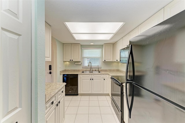 kitchen featuring light tile patterned floors, black appliances, and a sink