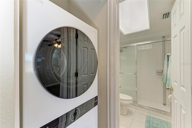 bathroom with toilet, a stall shower, tile patterned flooring, and visible vents