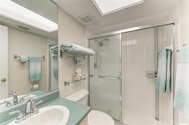 full bath featuring toilet, a shower stall, visible vents, and vanity