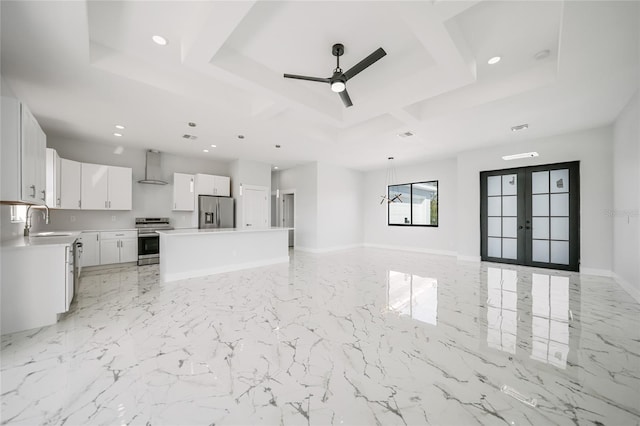 unfurnished living room with sink, french doors, ceiling fan, and a tray ceiling