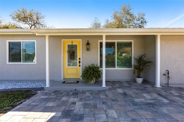 view of exterior entry with stucco siding