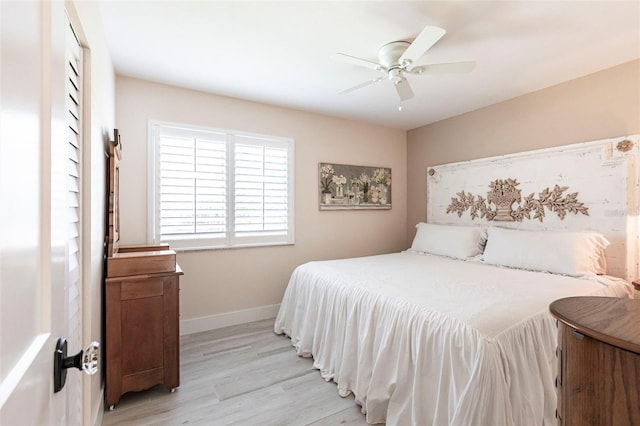 bedroom with light wood finished floors, baseboards, and a ceiling fan