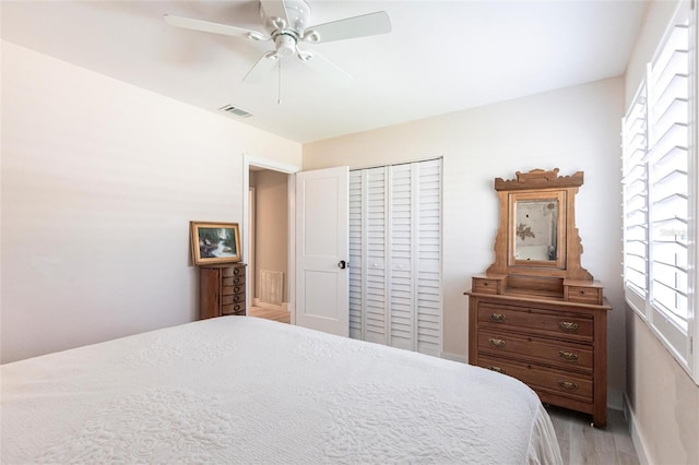 bedroom with light wood-style floors, a closet, visible vents, and ceiling fan