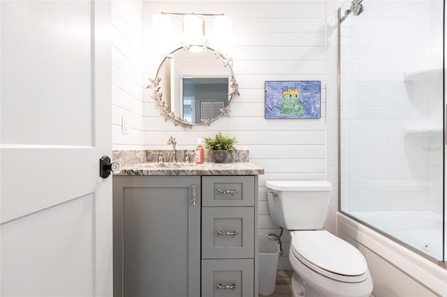 full bathroom with toilet, shower / bath combination with glass door, and vanity