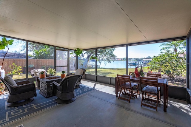 sunroom featuring a water view