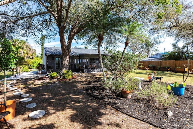 view of yard with fence and a sunroom