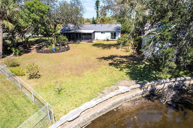 view of yard featuring a water view and fence