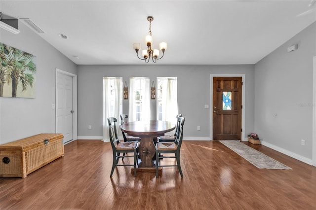 dining room with baseboards, dark wood-type flooring, and a notable chandelier