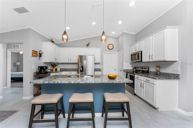 16265 Juarez Cir, Punta Gorda, FL 33955 - kitchen featuring appliances with stainless steel finishes, backsplash, and a kitchen bar