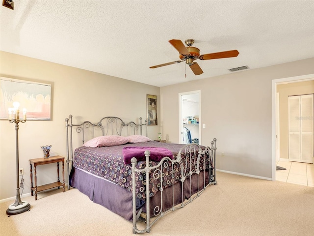 bedroom featuring visible vents, carpet flooring, a textured ceiling, and a spacious closet