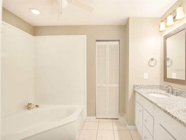 full bath featuring ceiling fan, tile patterned floors, vanity, a closet, and a tub