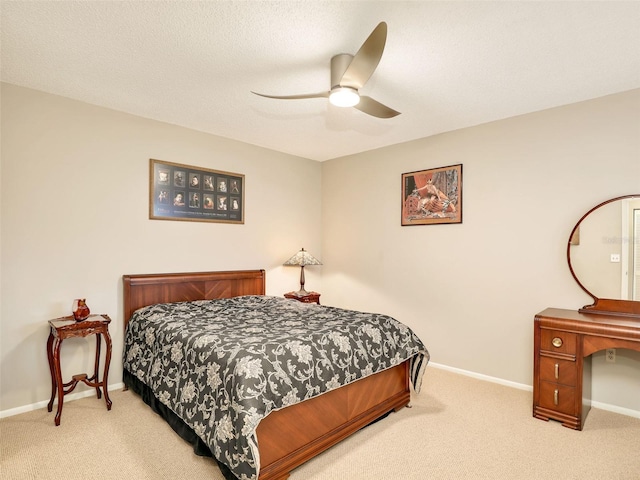 bedroom with a ceiling fan, baseboards, a textured ceiling, and light colored carpet