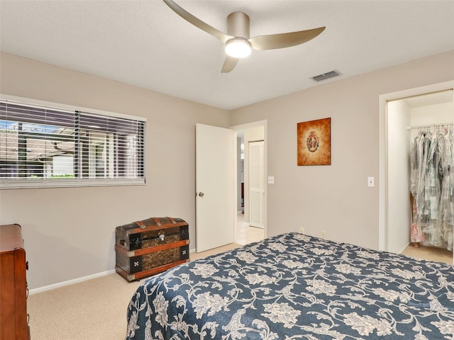 bedroom featuring light carpet, a textured ceiling, visible vents, and baseboards