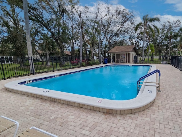 community pool with fence and an outbuilding