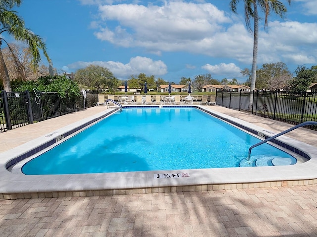 community pool with a patio and fence