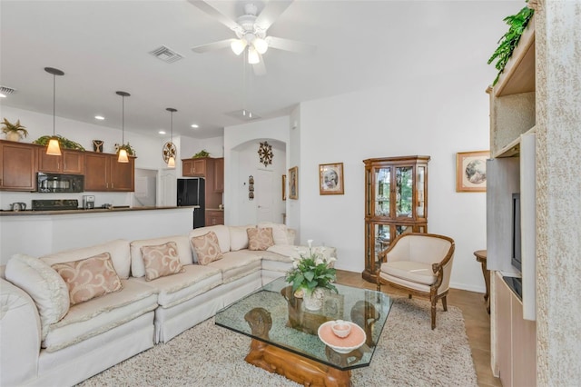 living room with a ceiling fan, arched walkways, visible vents, and recessed lighting