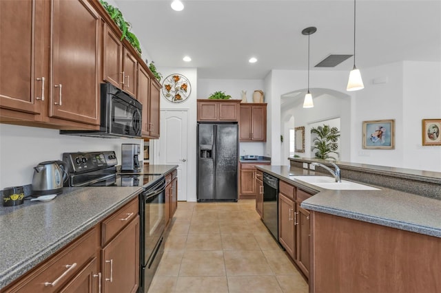 kitchen with light tile patterned floors, dark countertops, hanging light fixtures, a sink, and black appliances