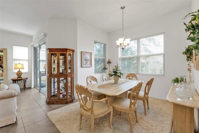 dining space with light tile patterned floors and a chandelier