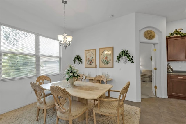 dining area featuring a chandelier and light tile patterned flooring