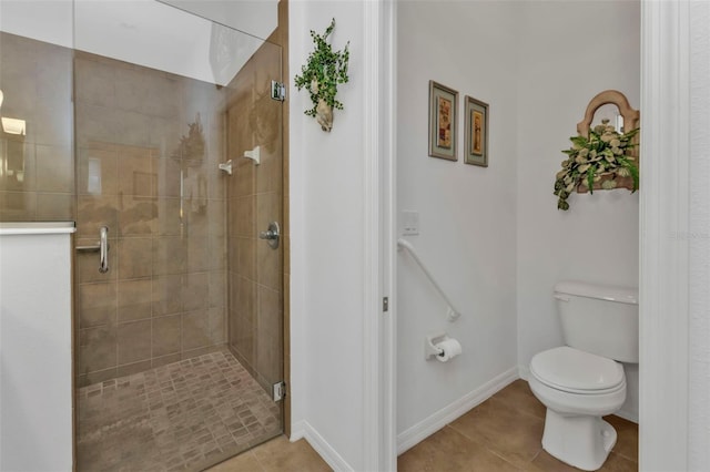 bathroom featuring toilet, a shower stall, baseboards, and tile patterned floors