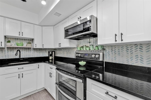 21287 Gertrude Ave Unit 106, Port Charlotte, FL 33952 - kitchen featuring open shelves, visible vents, appliances with stainless steel finishes, white cabinetry, and a sink