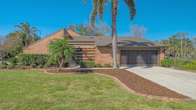 view of front of property featuring an attached garage, driveway, brick siding, and a front yard