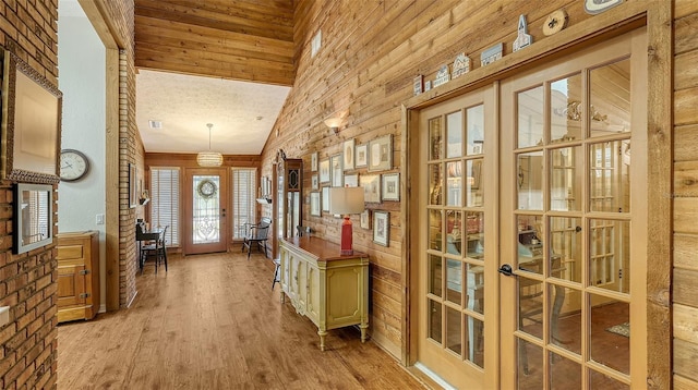 entryway with light wood-style floors, french doors, and high vaulted ceiling