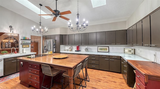 kitchen featuring appliances with stainless steel finishes, a skylight, pendant lighting, and light countertops