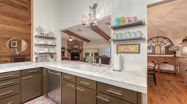 kitchen featuring open shelves, light countertops, a brick fireplace, open floor plan, and a sink