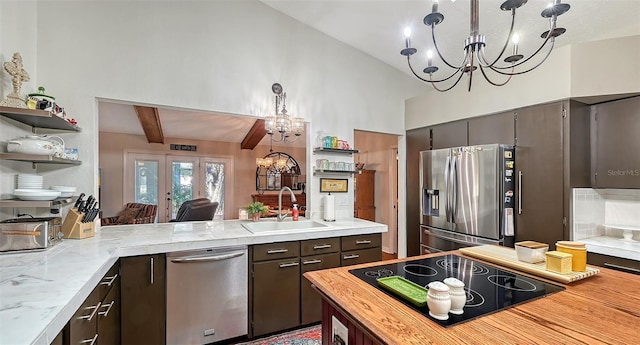 kitchen featuring stainless steel appliances, a chandelier, a sink, and hanging light fixtures