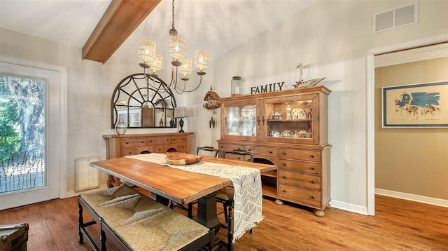 dining room with vaulted ceiling with beams, a notable chandelier, visible vents, light wood-style flooring, and baseboards