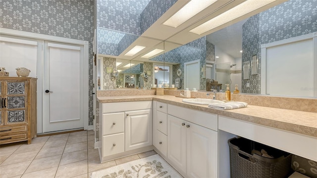 bathroom featuring wallpapered walls, tile patterned flooring, tiled shower, and vanity