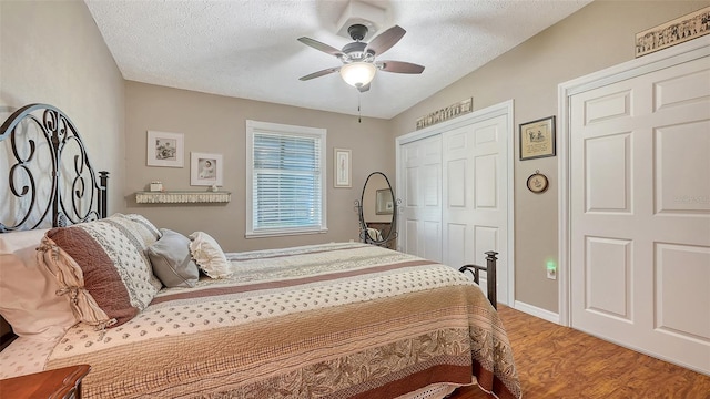 bedroom featuring a closet, a ceiling fan, a textured ceiling, wood finished floors, and baseboards