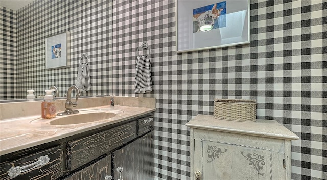 bathroom featuring vanity and wallpapered walls