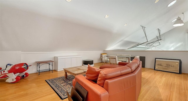 living area featuring vaulted ceiling and wood finished floors