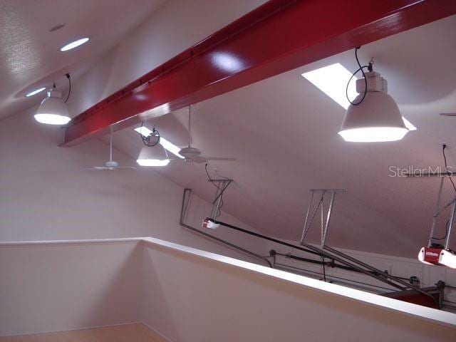 interior space with ceiling fan, beamed ceiling, and a garage door opener